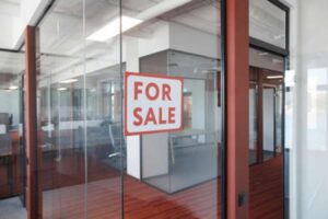 The interior of an office building with a "for sale" sign