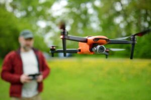 A man flies a drone in a backyard