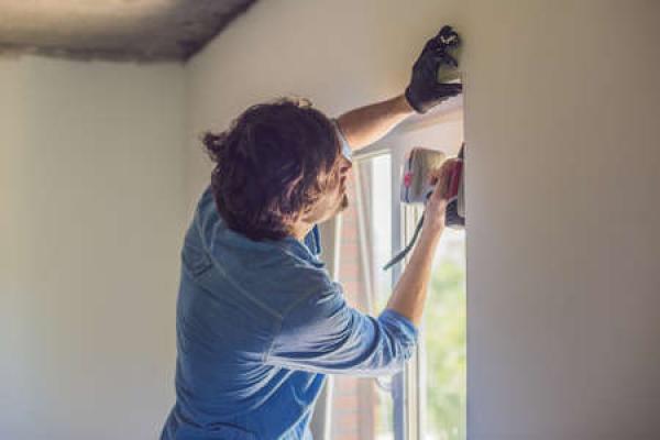 A person puts a new window into place in their home